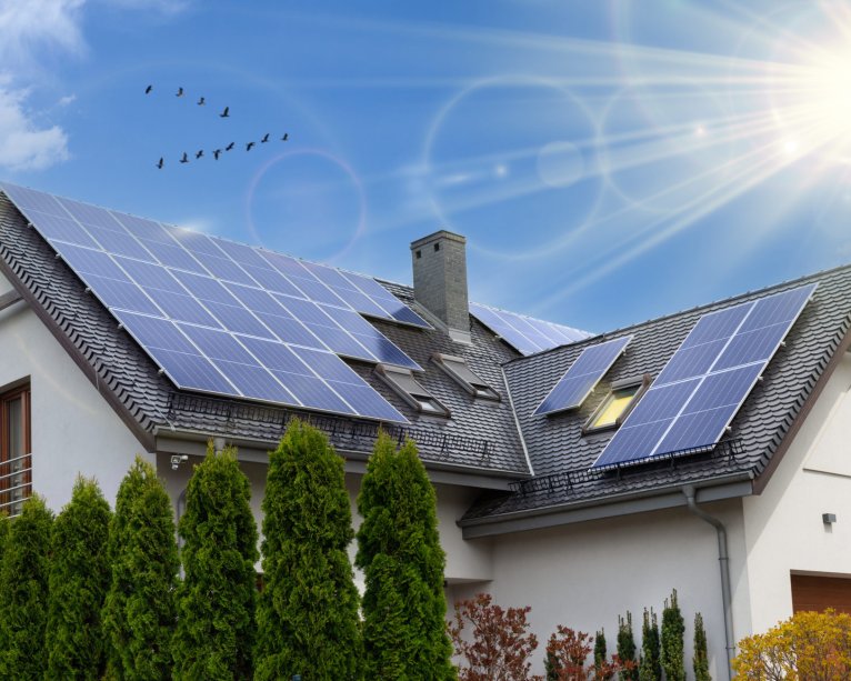Solar panels on a gable roof. Beautiful, large modern house and solar energy. Rays of the sun.
